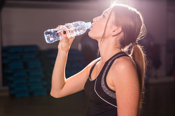 image femme qui s'hydrate pendant une séance de CrossFit